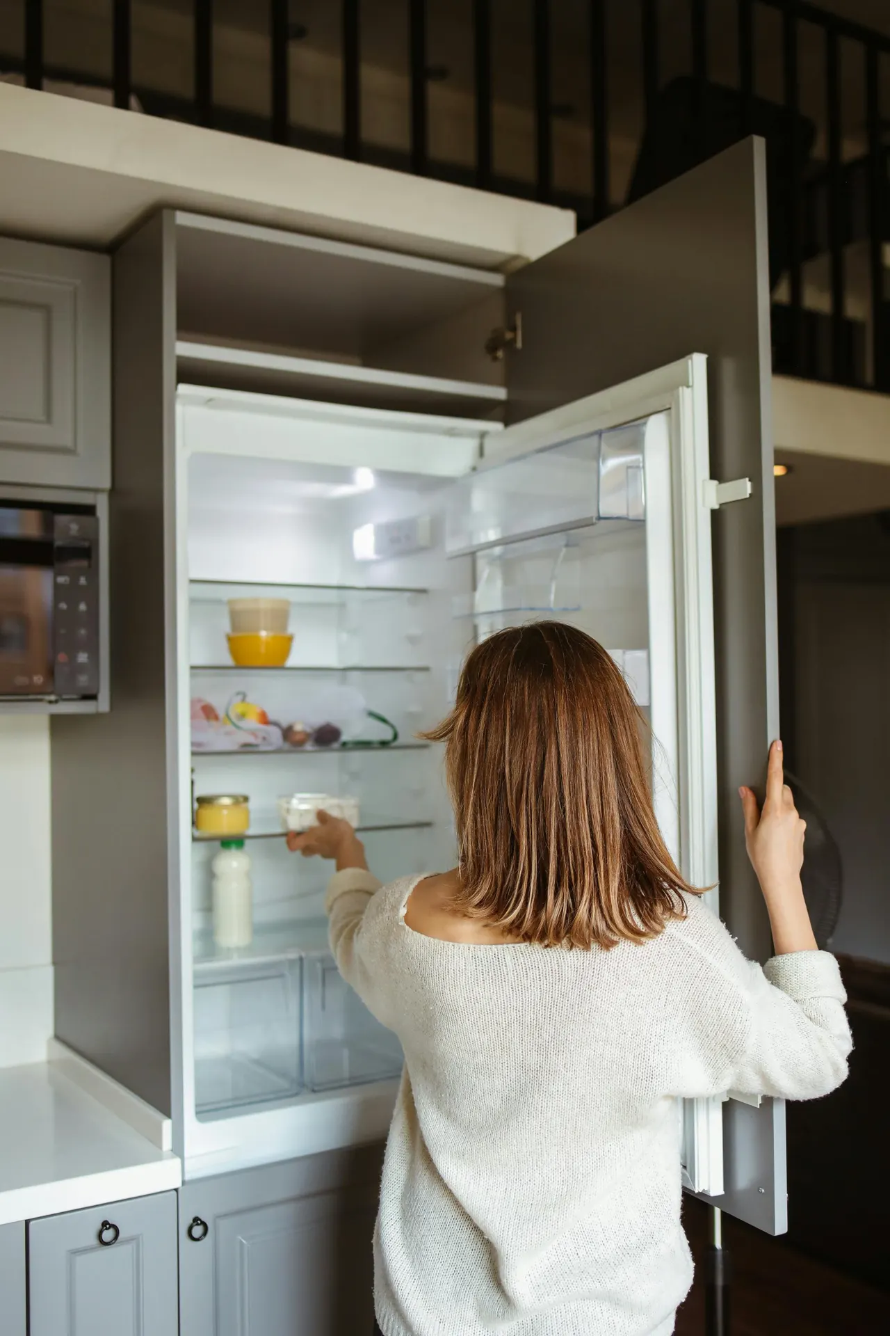 Mujer abriendo un frigorífico eficiente en su cocina