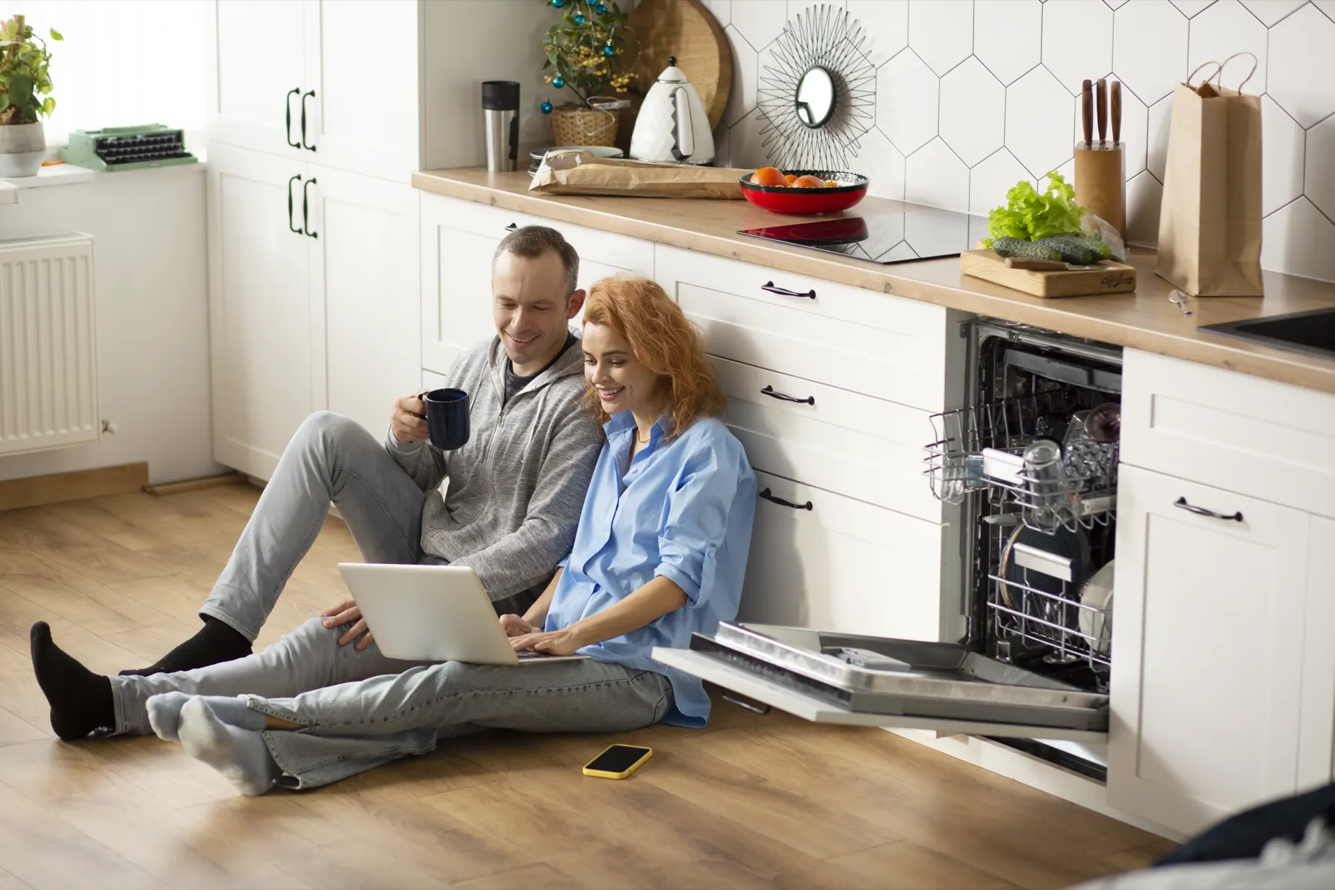 Pareja disfrutando en su cocina junto a un lavavajillas eficiente