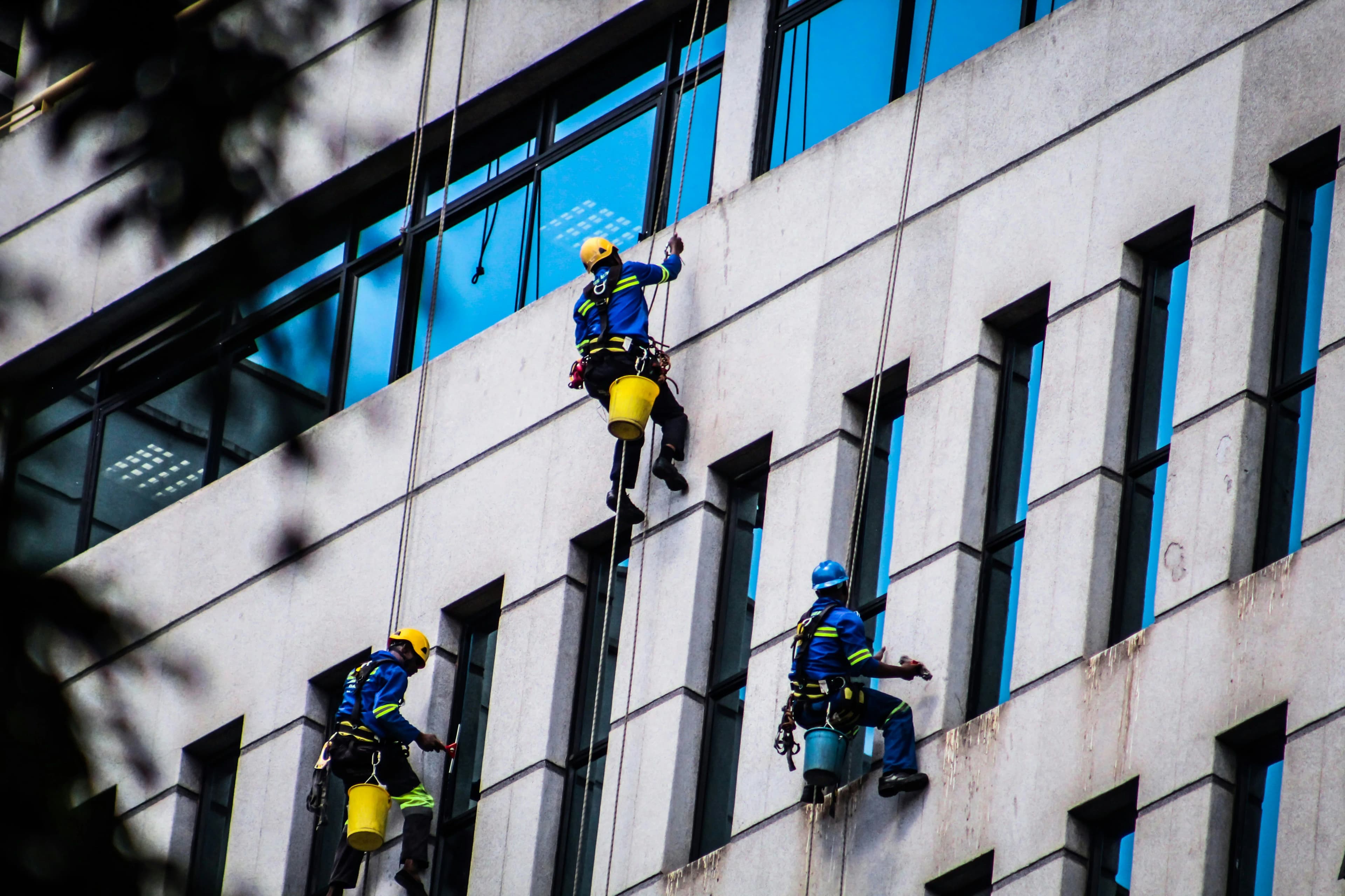 Operarios con arnés trabajando en la rehabilitación de la fachada de un edificio