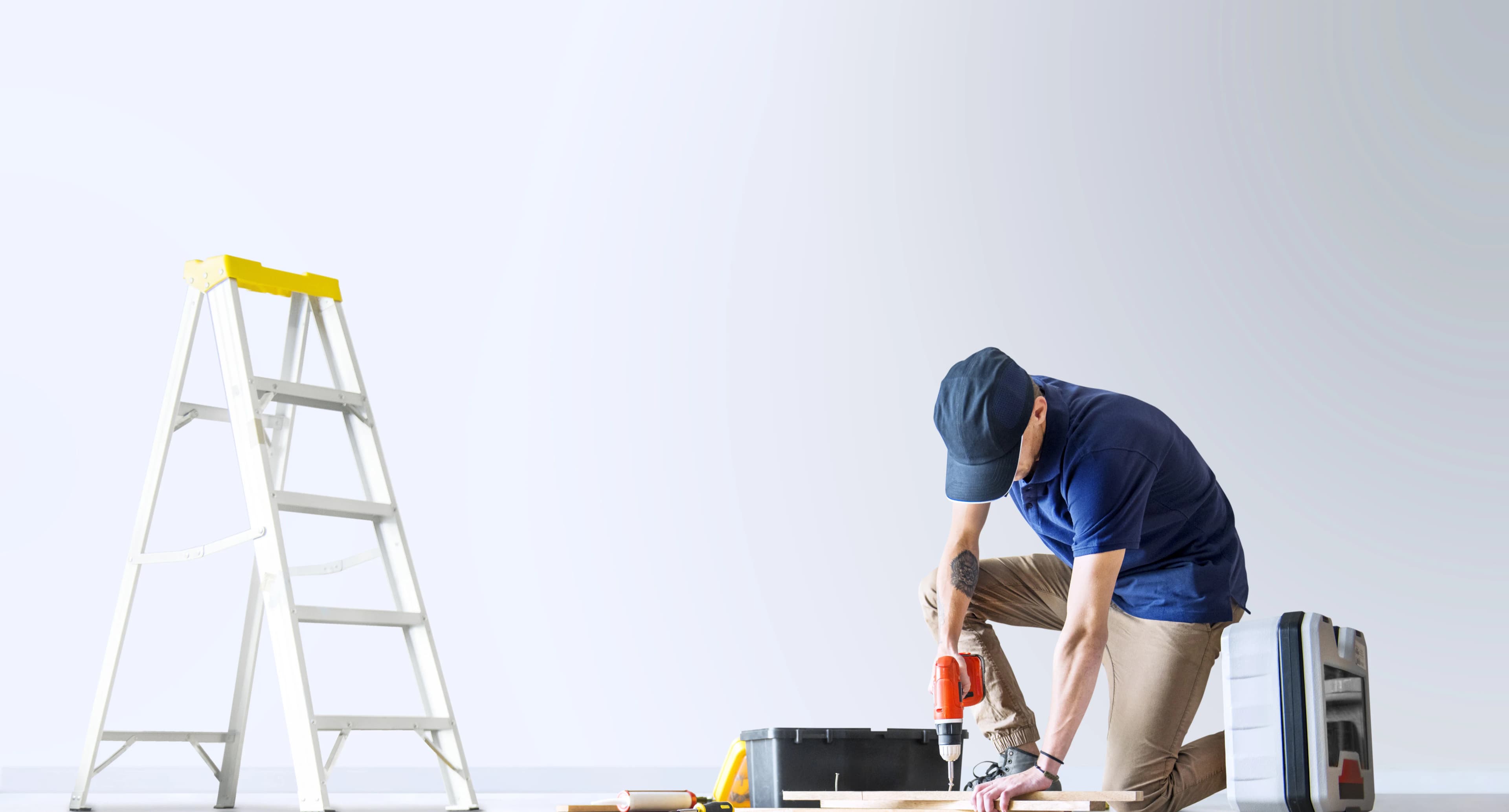 Profesional realizando trabajos de reforma en una vivienda con herramientas y escalera
